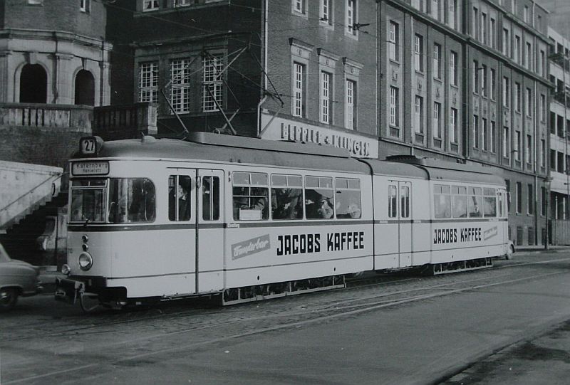 Eine Straßenbahn vor einer Gebäudezeile.
